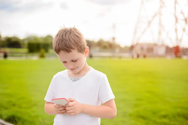 Menino criança jogando jogos móveis no smartphone — Fotografia de Stock