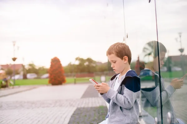 Menino criança jogando jogos móveis no smartphone — Fotografia de Stock