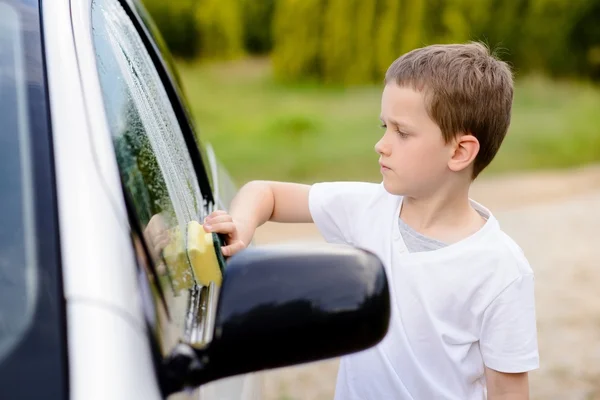 Niño pequeño lavando coche de plata en el jardín — Foto de Stock