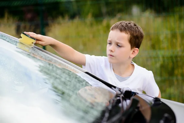 Mały chłopiec mycia samochodu srebrny w ogrodzie — Zdjęcie stockowe