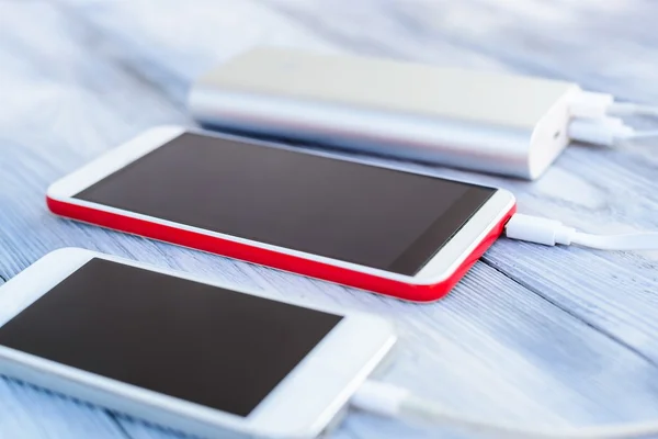 Powerbank cobrando smartphone branco e vermelho — Fotografia de Stock
