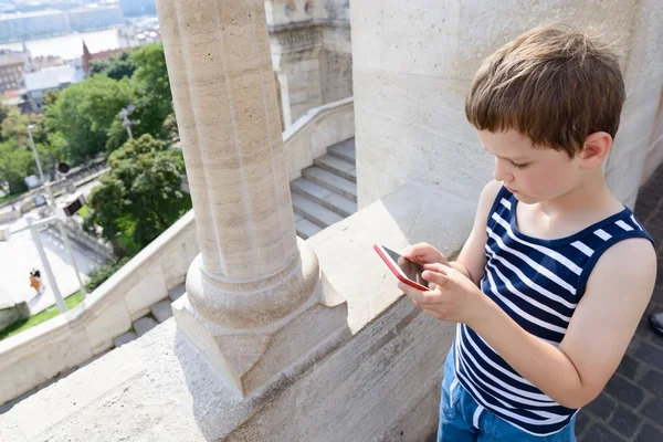 Petit garçon de 7 ans jouant à des jeux mobiles sur smartphone — Photo
