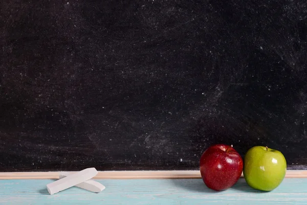 Tableau noir avec craie et deux pommes — Photo