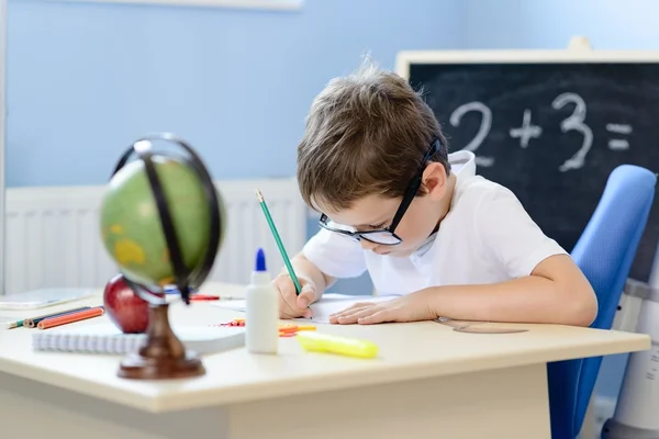 7 years old boy solves multiplication table in his copybook. — Stock Photo, Image
