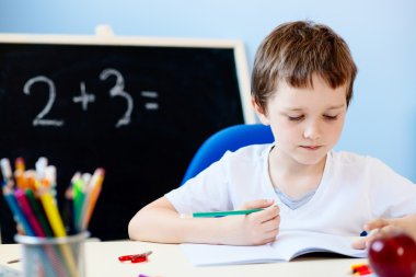Çocuk ödevini yapıyor.