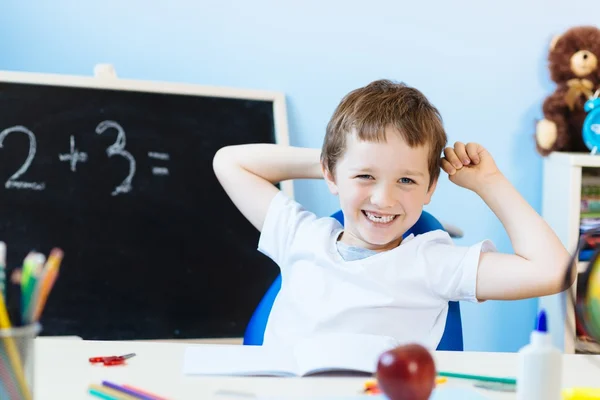 Glücklicher siebenjähriger Junge im Klassenzimmer — Stockfoto