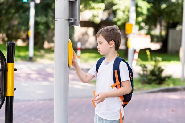 Schüler mit Rucksack drückt einen Knopf im Straßenverkehr — Stockfoto