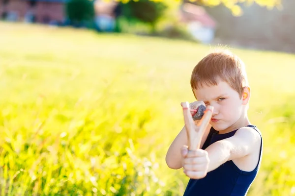 Little boy playing with slingshot — Stock Photo, Image