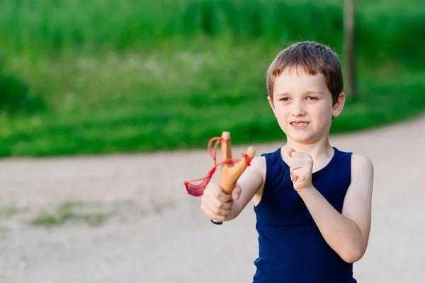 Little boy playing with slingshot — Stock Photo, Image