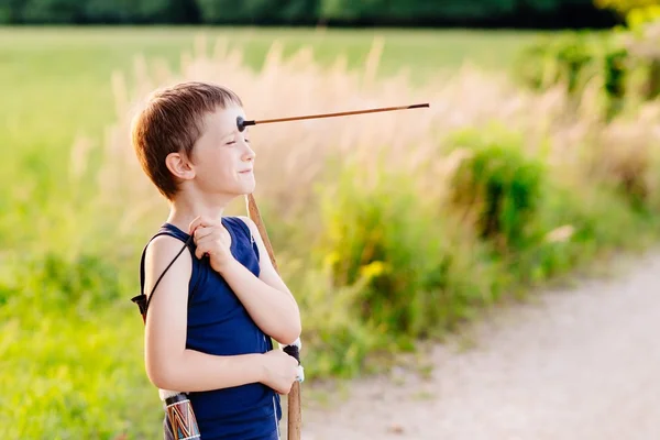 Boy playing playing with bow and toy arrow — Stock Photo, Image
