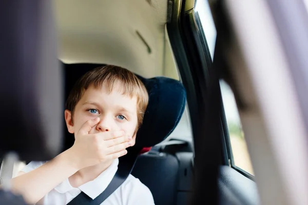 Criança sofre de enjoo de movimento no carro — Fotografia de Stock