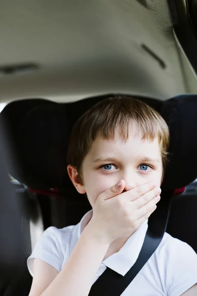 Criança sofre de enjoo de movimento no carro — Fotografia de Stock