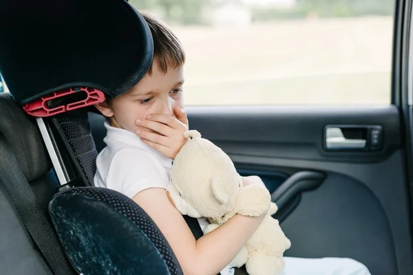 Criança sofre de enjoo de movimento no carro — Fotografia de Stock