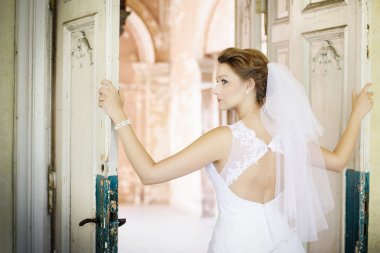 Eski kapı yakınındaki beyaz elbiseli genç güzel gelin