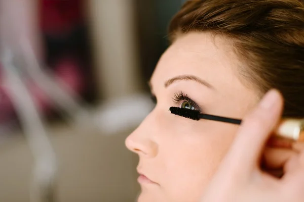 Maquillaje artista aplicando rímel en las pestañas de la novia . — Foto de Stock