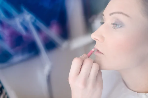 Maquillaje artista aplicar lápiz labial en los labios de la novia . — Foto de Stock