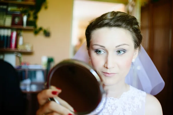 Jovem noiva olhando no espelho . — Fotografia de Stock