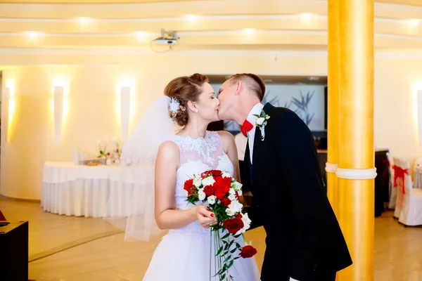 Recién casados primer beso en fiesta de bodas . — Foto de Stock