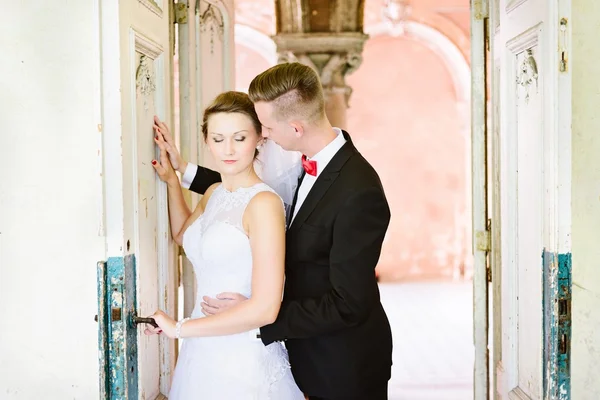 Jeune belle mariée et marié près de la vieille porte — Photo