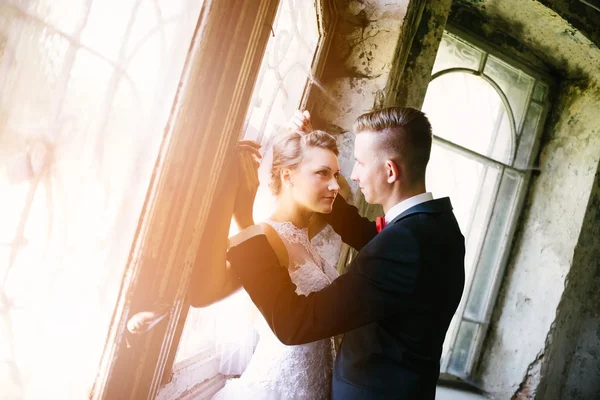 Newlyweds kissing near old door — Stock Photo, Image