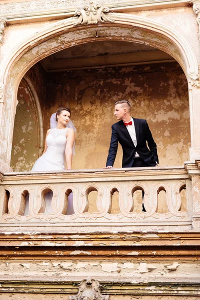 Bride and groom on the balcony in the old castle. — Stock Photo, Image