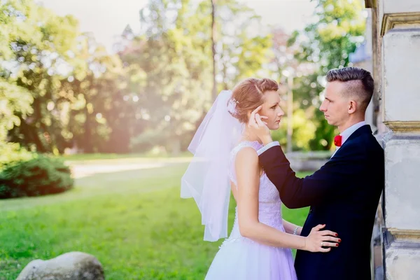 Jonge mooie bruid en bruidegom kussen — Stockfoto