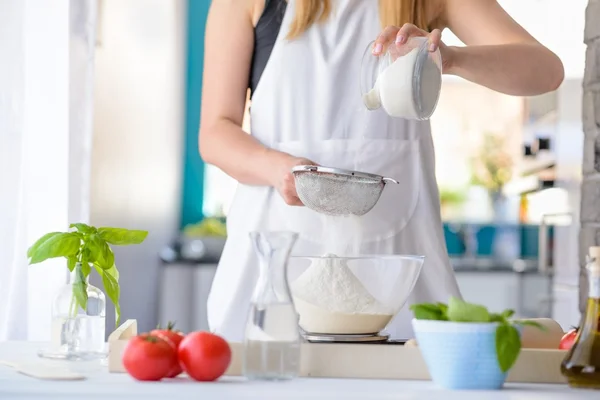 Frau sieben Mehl durch Sieb. — Stockfoto