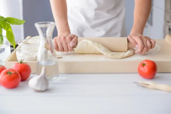 Mujer rodando masa de pizza usando rodillo . — Foto de Stock