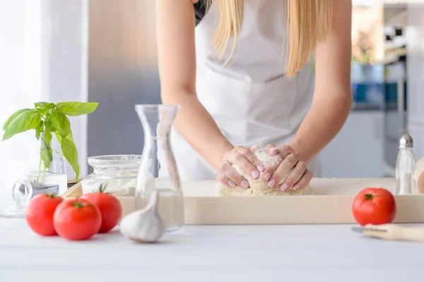 Mujer amasando masa de pizza en tablero de repostería de madera — Foto de Stock