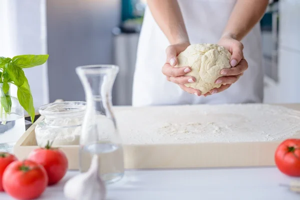 Mujer amasando masa de pizza en tablero de repostería de madera — Foto de Stock