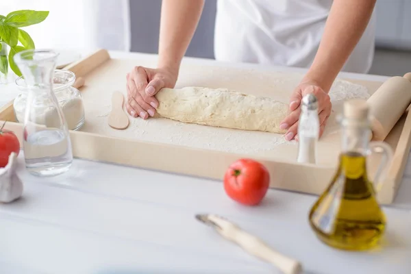 Mujer amasando masa de pizza en tablero de repostería de madera —  Fotos de Stock