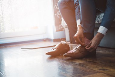 Adam bir takım elbise giymiş deri ayakkabı takılır