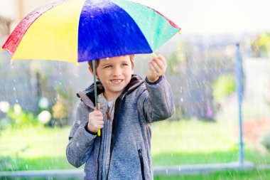 Yedi yaşında çocuk yağmur ayakta