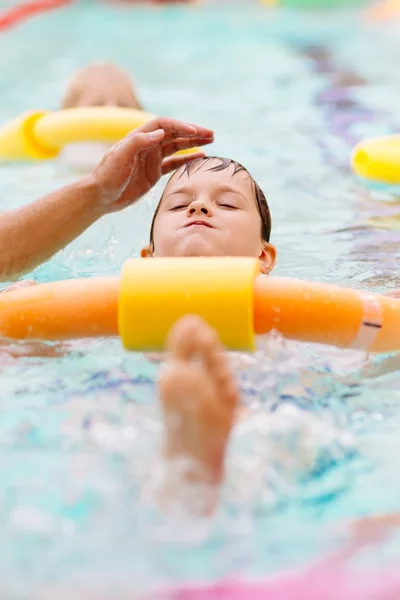7 歳の少年はプールで泳ぐことを学ぶ. — ストック写真