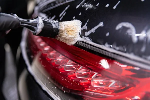 Auto detailně studio pracovník čištění auto s kartáčkem — Stock fotografie