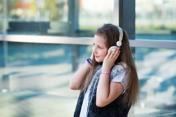 Chica joven y feliz escucha música en los auriculares. —  Fotos de Stock
