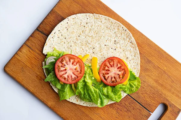 Wheat tortilla wrap with green lettuce and tomato — Stock Photo, Image