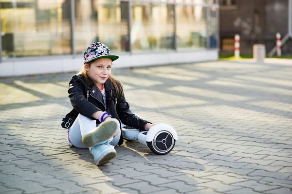 A fiatal, elégedett lány egy deszkán pihen valahol a városban.. — Stock Fotó