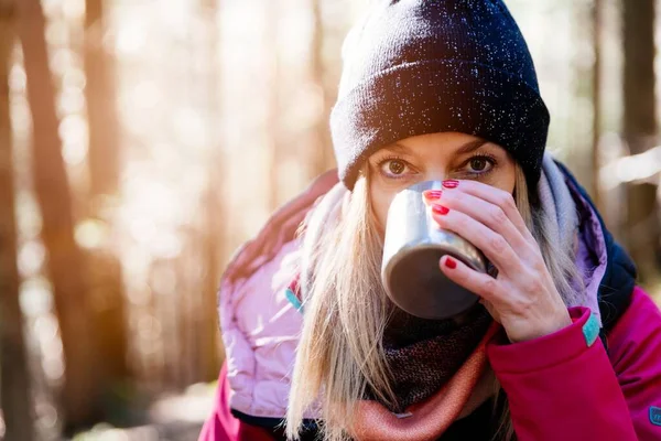 Турист п'є гарячий чай на гірській стежці в холодний день . — стокове фото