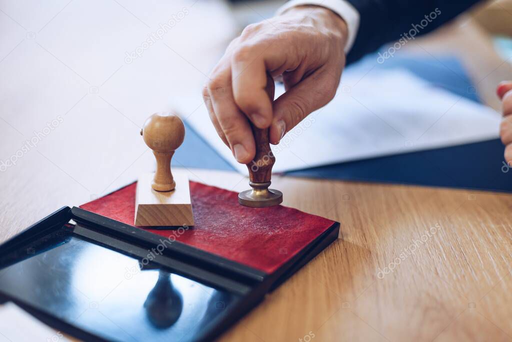 Man lawyer holding notary public ink stamper