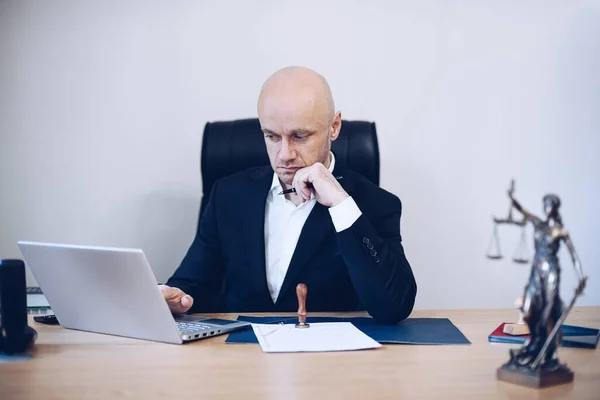 Un avvocato di sesso maschile seduto in ufficio. Lavorare sul caso. — Foto Stock