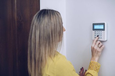 Kadın güvenlik paneline güvenlik şifresi giriyor