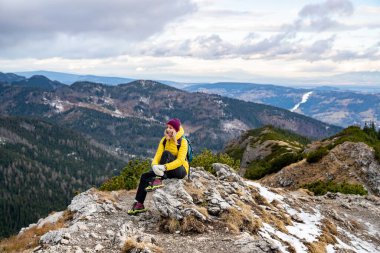 Kadın bir gezgin üstte oturur. Güzel dağ ve tepe manzarası.