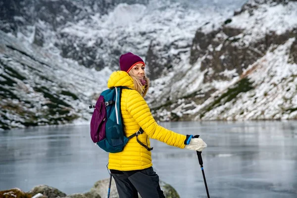 Усміхнений рюкзак жінка з полюсами на стежці в горах . — стокове фото