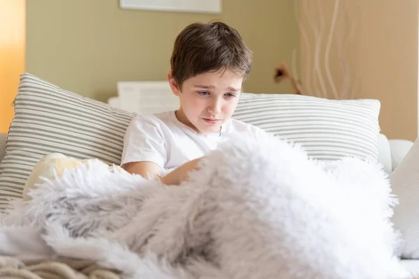 生病的男孩坐在毛毯下感觉不舒服. — 图库照片