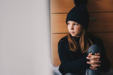 Pencereden bakan üzgün kız.