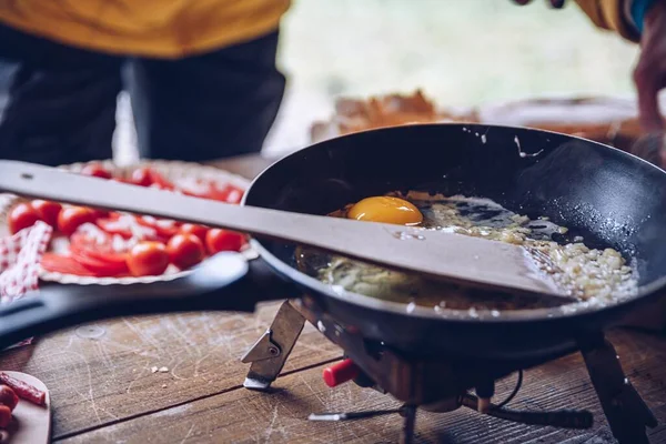 Женщина готовит вкусный туристический завтрак в кемпинге. Яичница на открытом воздухе. — стоковое фото