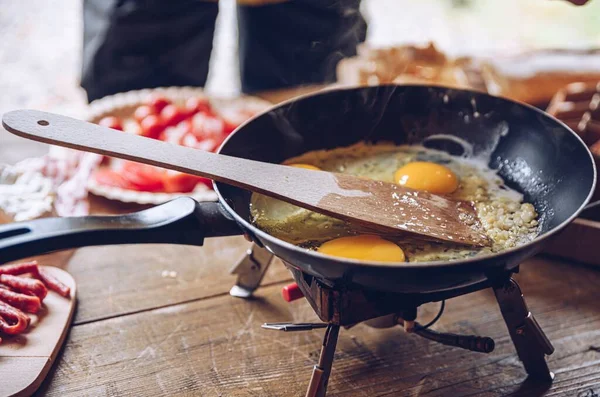 Женщина готовит вкусный туристический завтрак в кемпинге. Яичница на открытом воздухе. — стоковое фото