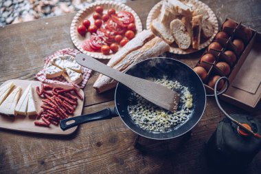 Dağlarda çırpılmış yumurta için soğan kızartıyorum. Turist kadın dışarıda lezzetli bir turist kahvaltısı hazırlıyor..