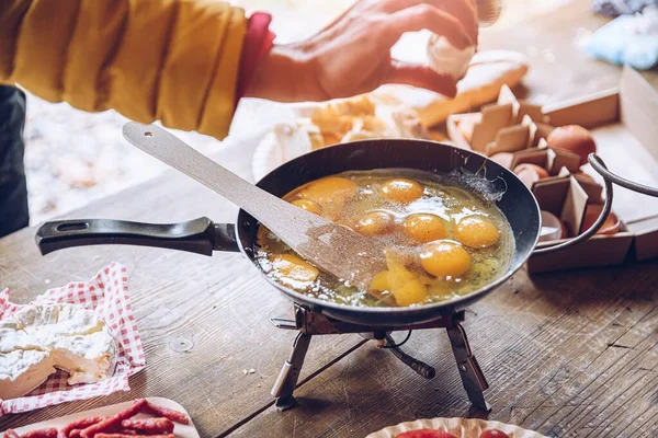 Delicioso desayuno turístico en el camping. Freír huevos revueltos al aire libre. —  Fotos de Stock